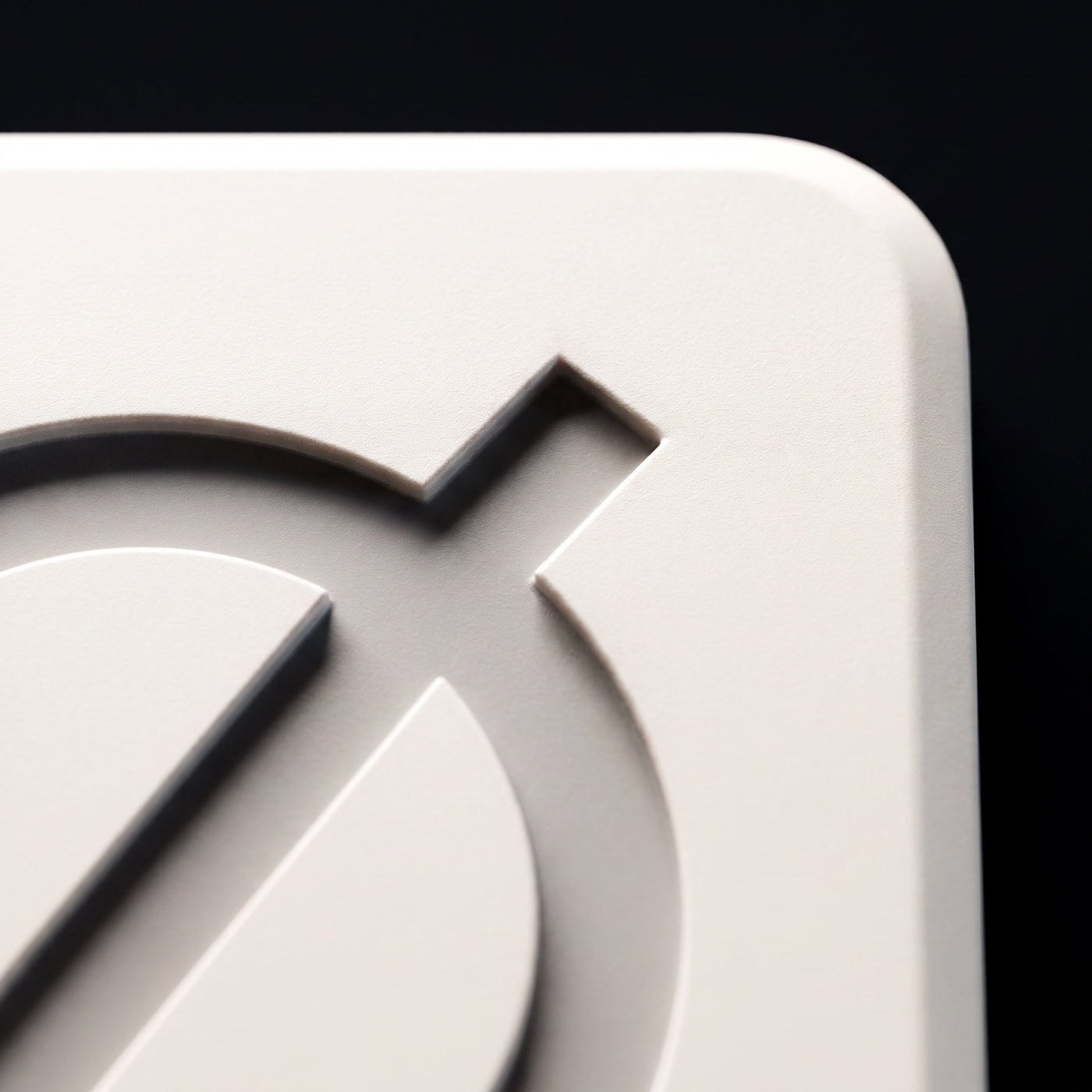 Macro detail of the debossed Ø mark in soft-touch bone-white polymer